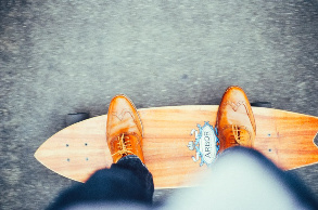 Mann mit Anzug auf dem Skateboard
